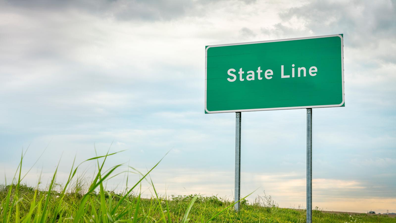 a traffic sign depicting a state line border