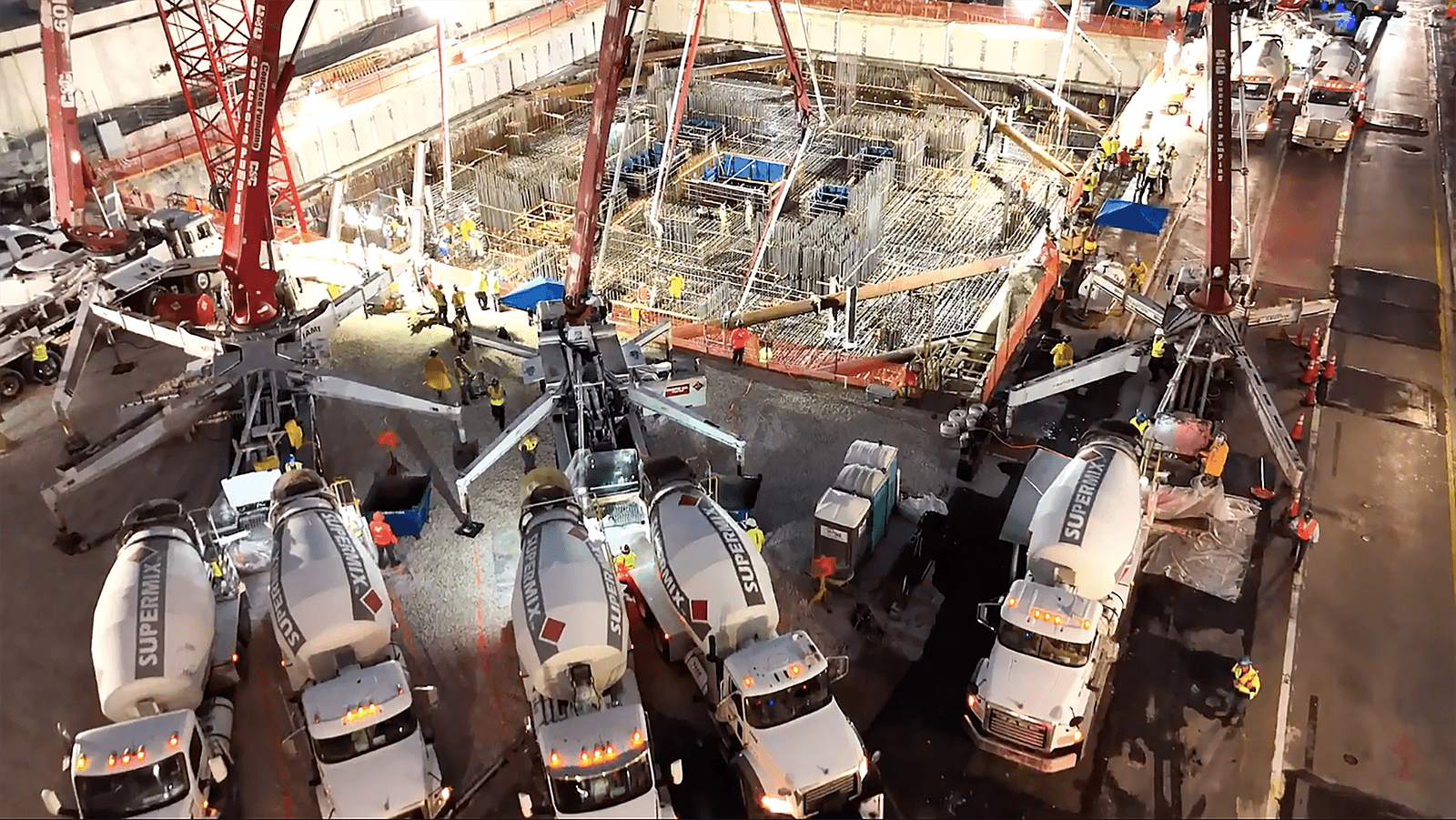 several concrete trucks lined up at the Waldorf Astoria foundation for a record-breaking concrete pour