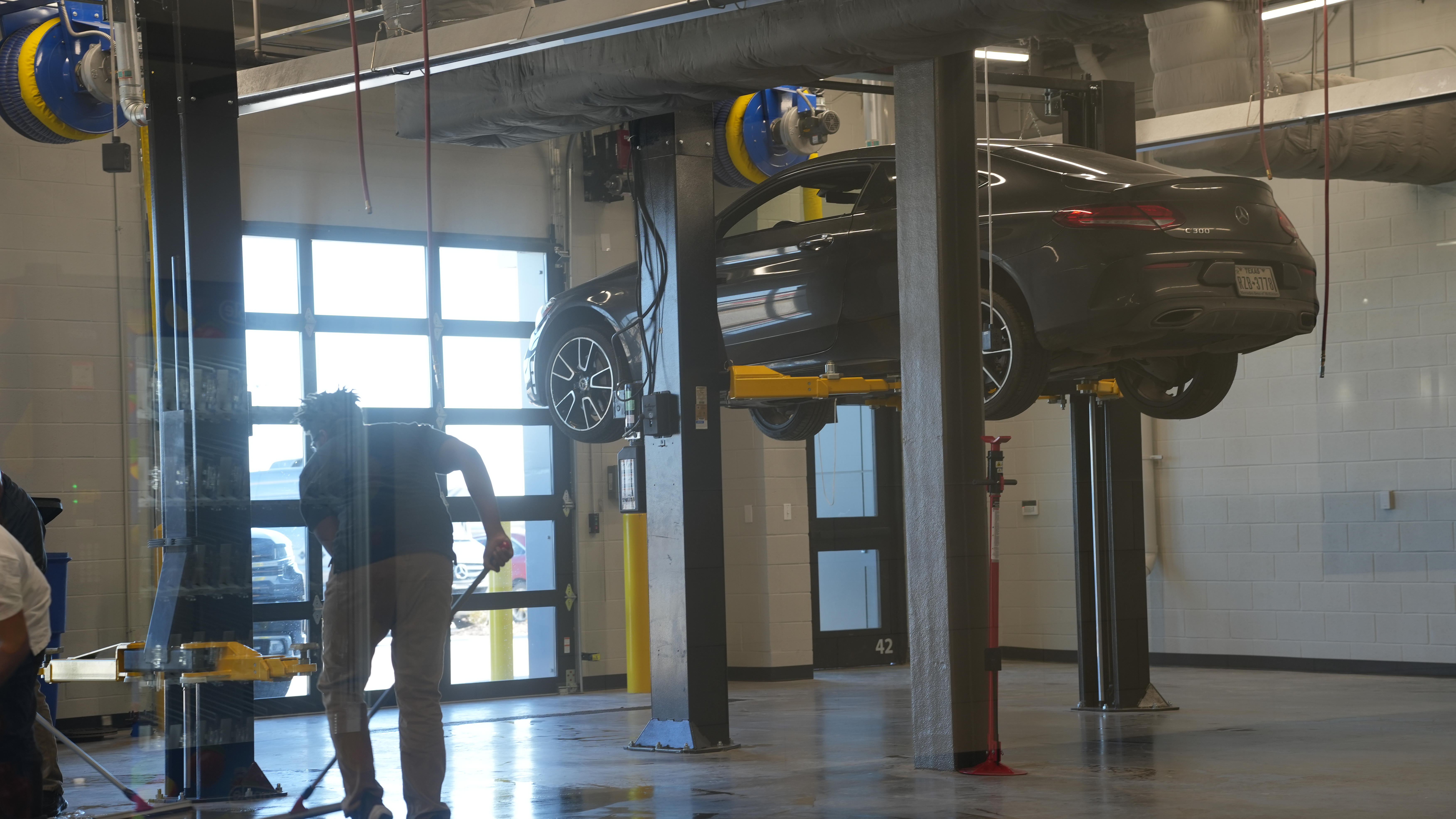 A car hoisted on a hydraulic lift inside the auto-mechanic classroom at The OC