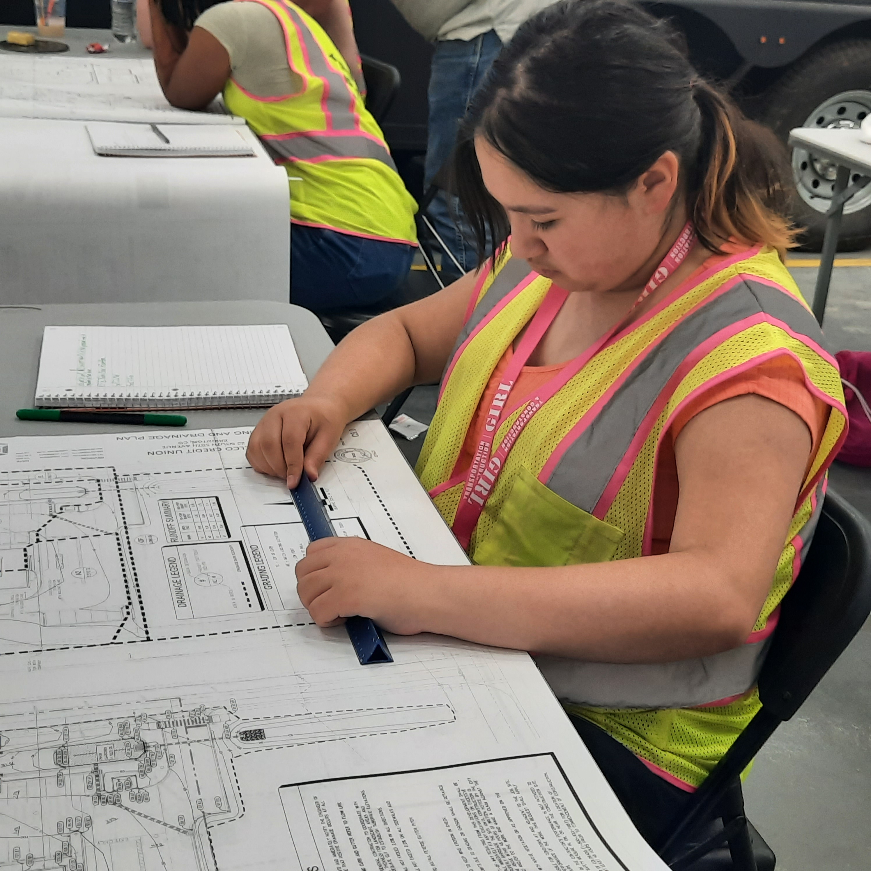 a girl learning how to read architecture blueprints
