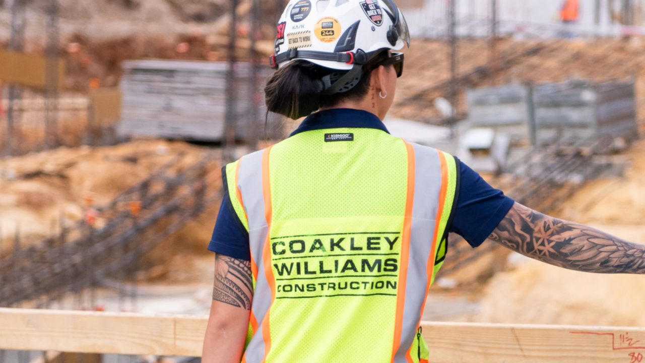 A female construction worker from Coakley Williams Construction working on a construction site.