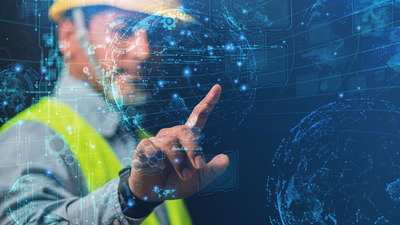 a construction worker touching a holographic projection of the earth and other graphs.