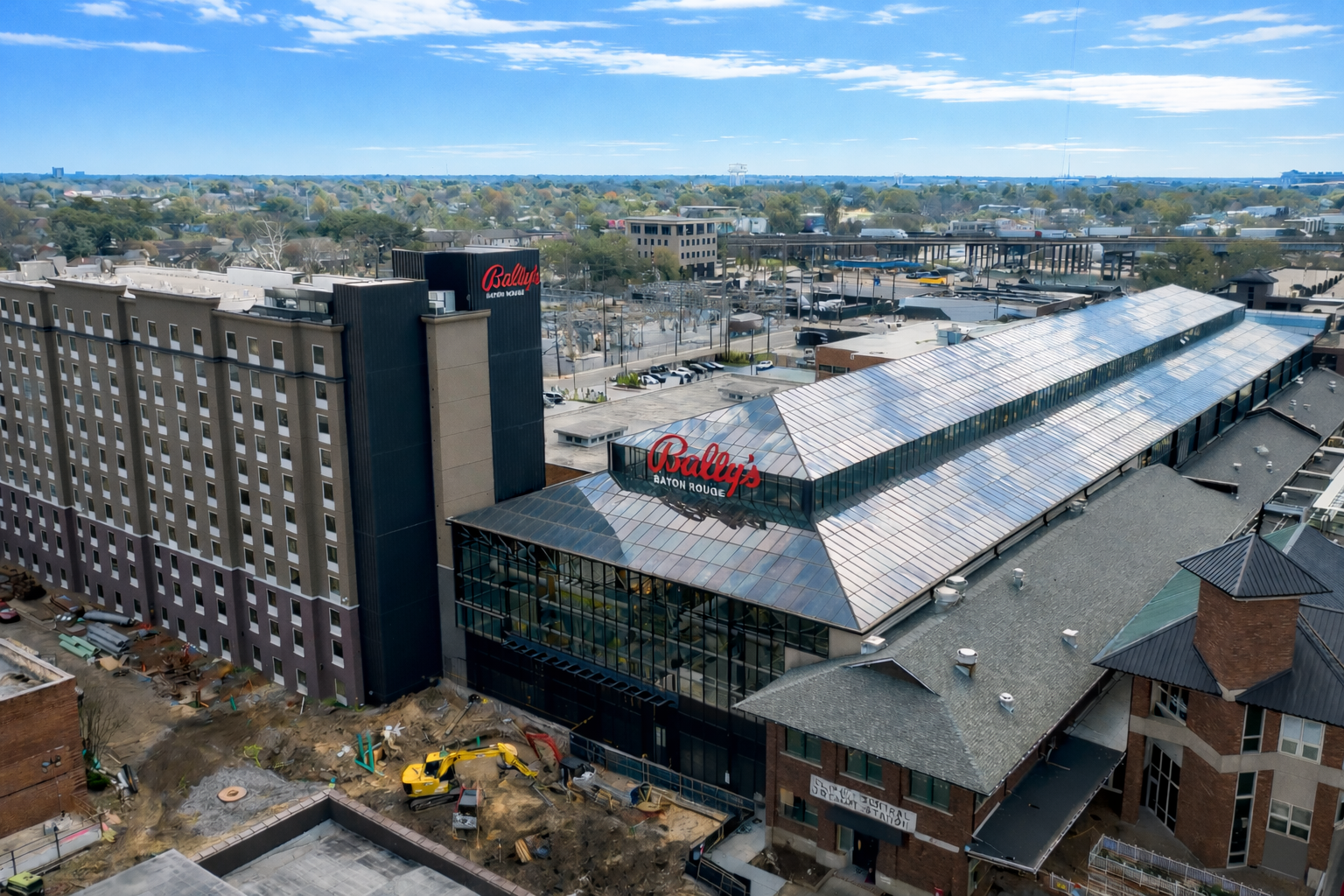 Aerial view of Bally's Baton Rouge Hotel and Casino showing the hotel tower, glass-roofed casino structure, and surrounding construction site.