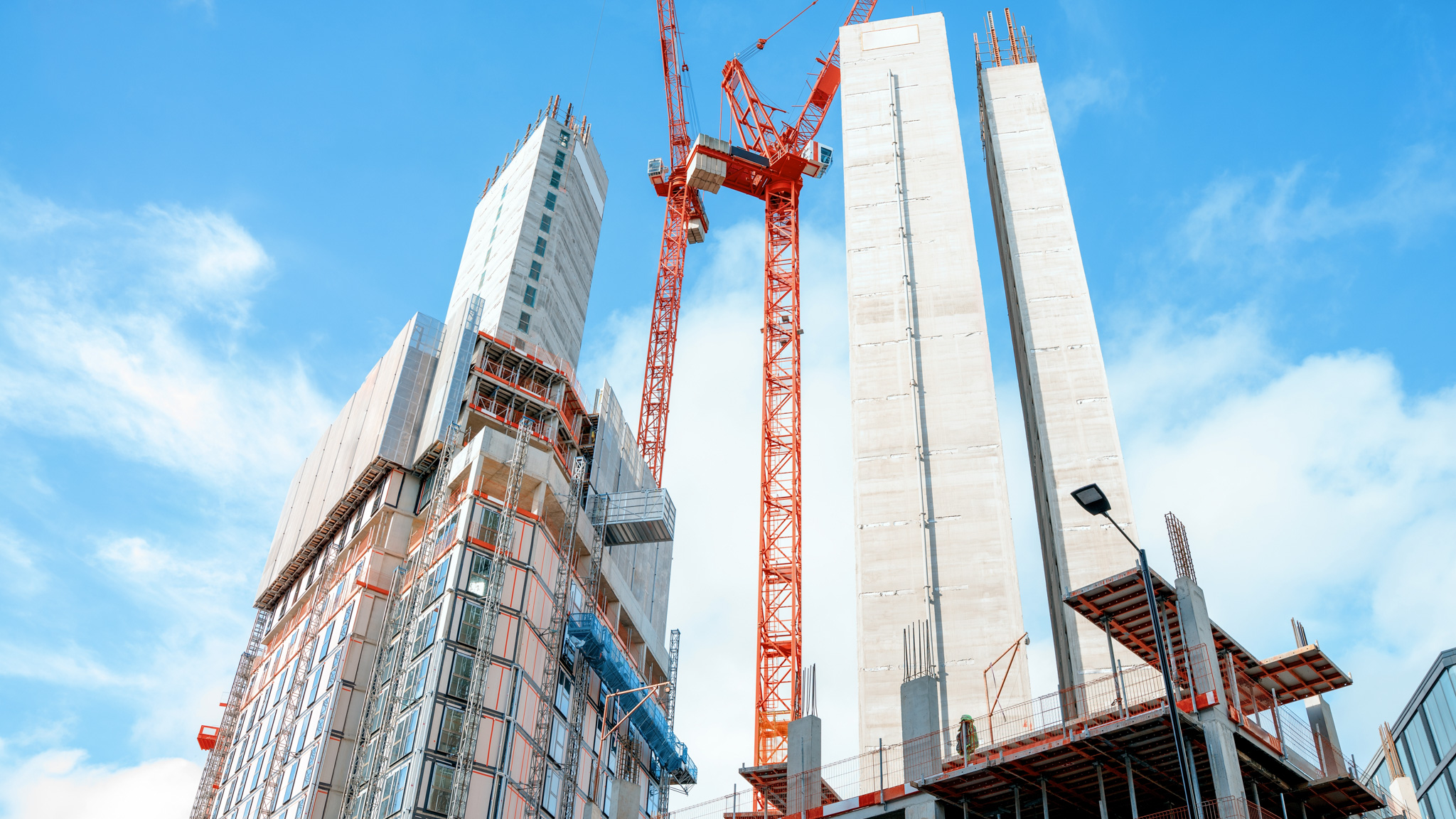 Construction,Site,In,City,With,Cranes,Lifting,Materials,Towards,New